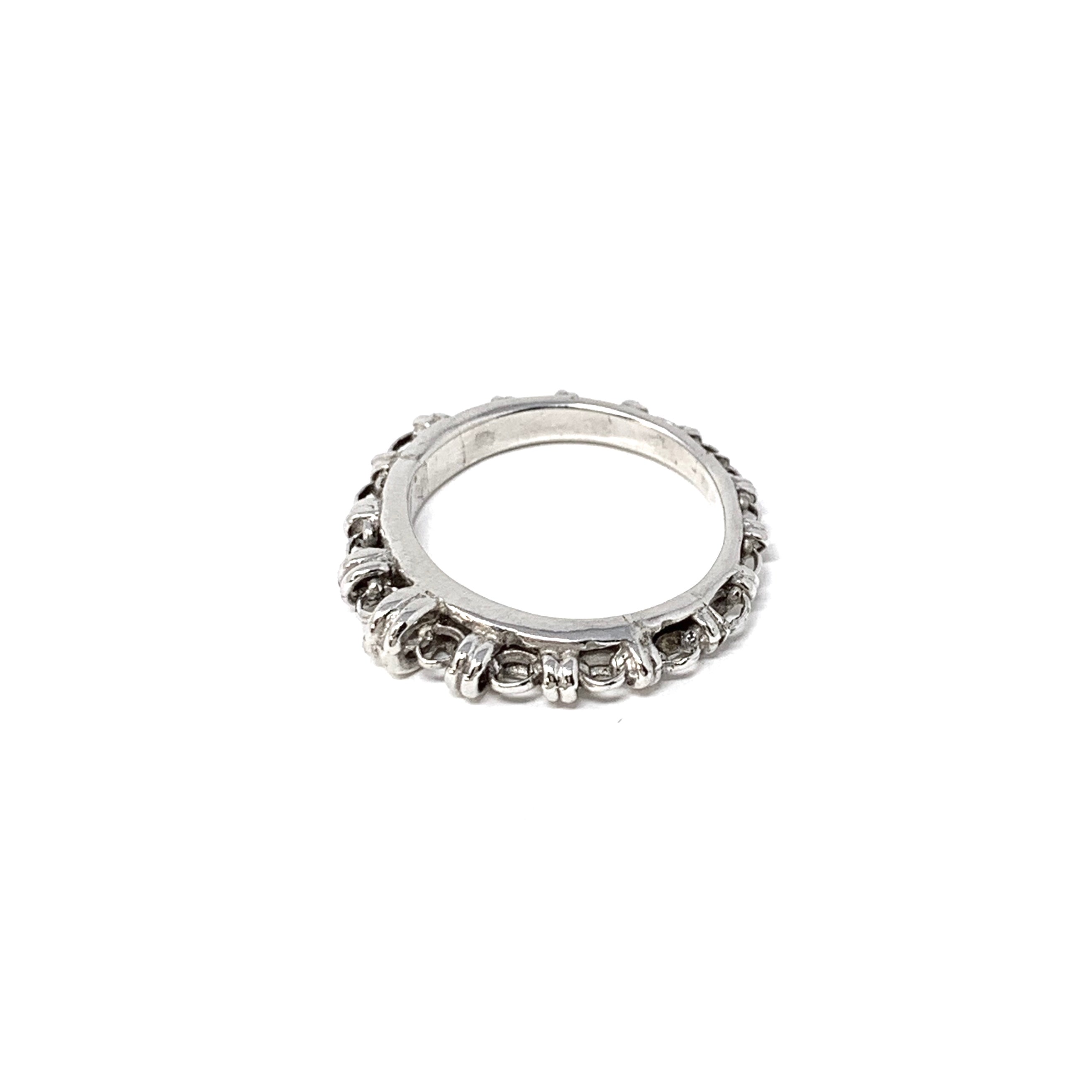 A silver ring with a silver chain design that has varying sizes of links to resemble a climb to the top - thus its Italian name ‘Scalare’: to climb - resting on its side on a white background. Designed and hand-crafted by DelBrenna Italian Jewelry designers and artisans in Tuscany.