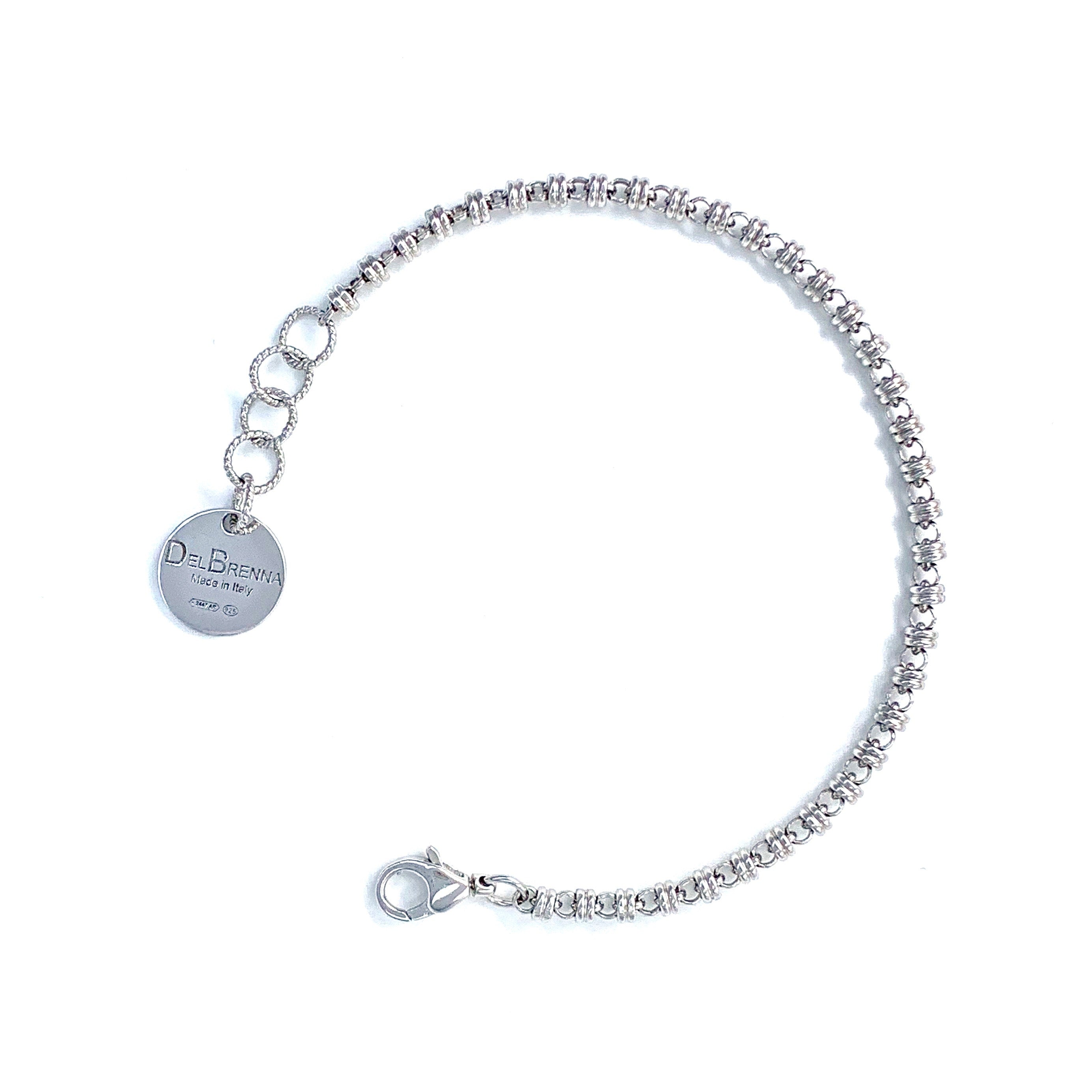 A silver chain bracelet with a round silver charm with the DelBrenna brand name against a white background. The silver bracelet has been handcrafted in Tuscany by DelBrenna Italian Jewelry artisans and designers. 