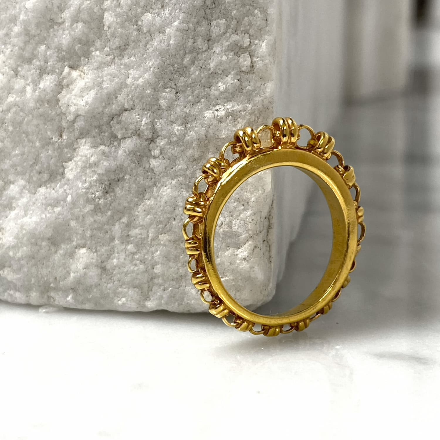 An angled view of a gold ring with a gold chain design that has varying sizes of links to resemble a climb to the top - thus its Italian name ‘Scalare’: to climb. Designed and hand-crafted by DelBrenna Italian Jewelry designers and artisans in Tuscany. 