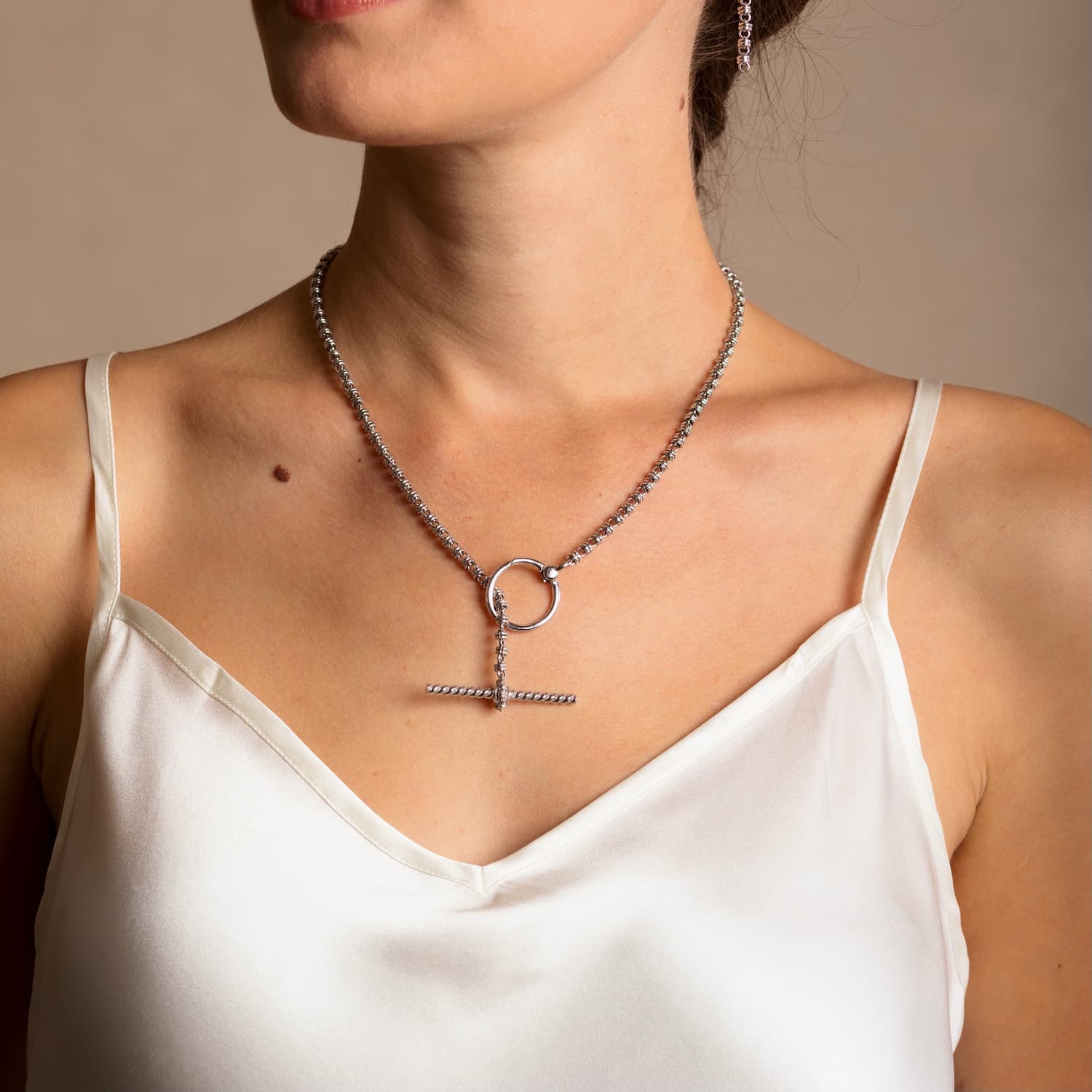 A person modeling a silver necklace with a toggle clasp and silver earrings to match the silver chain in the necklace - both from the Links 3mm collection from DelBrenna Italian Jewelry designers and artisans. Hand-crafted in Tuscany.