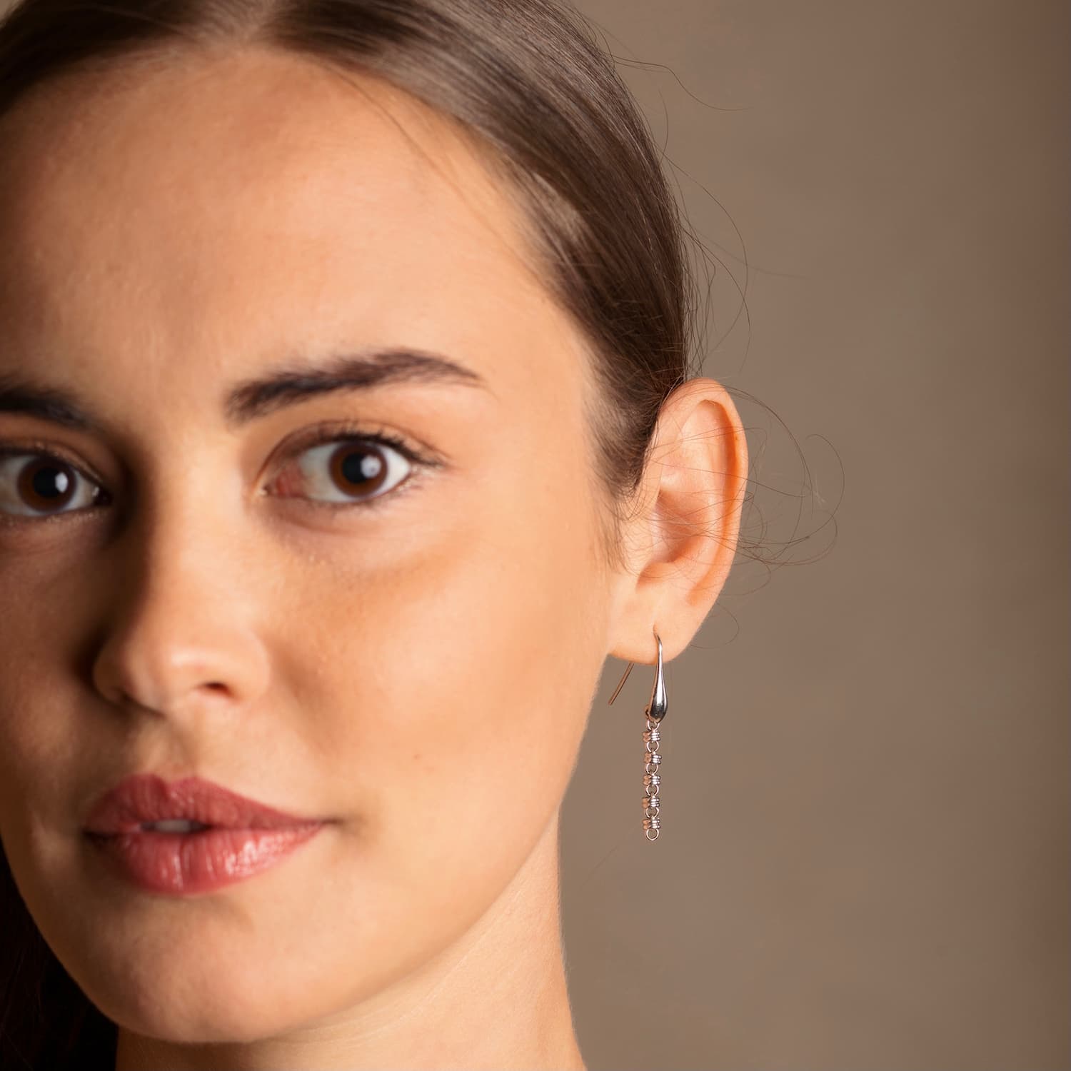 A closeup of a model wearing long silver chain earrings designed and hand-crafted by DelBrenna Italian Jewelers in Tuscany. The earrings are designed based on the iconic Links collection of DelBrenna silver chains, necklaces, rings, and bracelets.