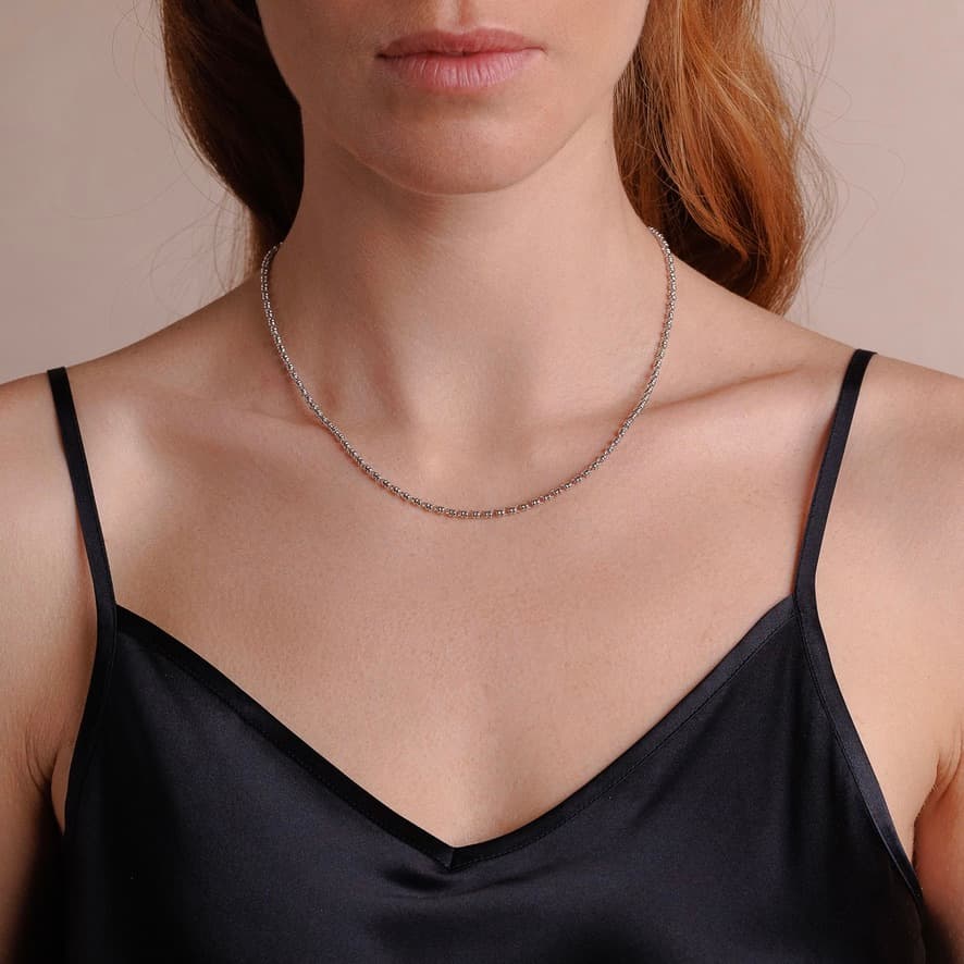 A front-facing, closeup view of a model wearing a short (16-inch) silver necklace. The necklace is a delicate 2MM version of the iconic silver chain designed by DelBrenna Italian jewelry designers in 1974 in Tuscany. 